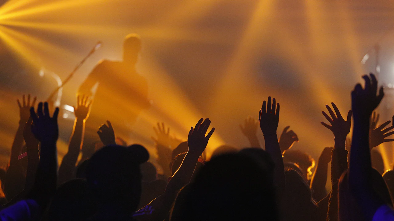 A congregation lifting their hands in golden light